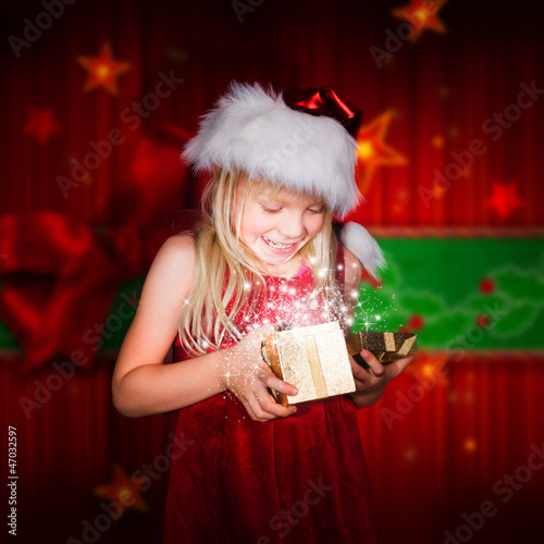 Photo: kleines Mädchen schaut in ein Geschenk kleines Mädchen schaut in ein Geschenk