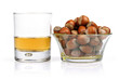 a glass of whiskey and a bowl of nuts