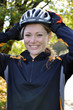 Junge Frau setzt Fahrradhelm auf