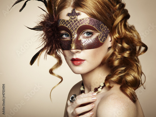 Photo: Beautiful young woman in brown mysterious venetian mask Beautiful young woman in brown mysterious venetian mask