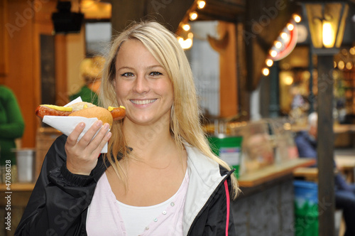 Photo: Junge Frau isst Rostbratwurst Junge Frau isst Rostbratwurst