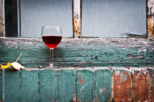 Photo: Verre de vin rouge sur un bord de fenêtre Verre de vin rouge sur un bord de fenêtre