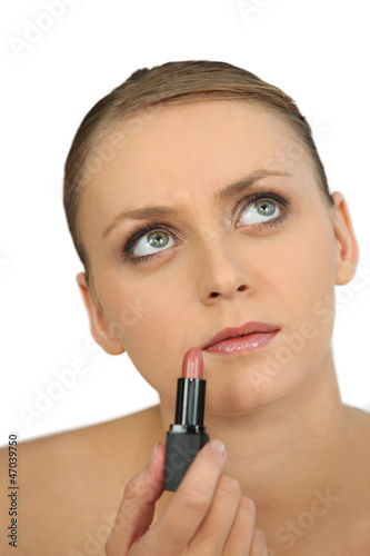 Photo: Woman applying pink lipstick Woman applying pink lipstick