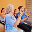 Seniorin beim Hanteltraining im Fitnesscenter