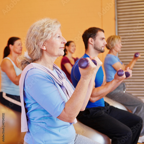 Photo: Seniorin beim Hanteltraining im Fitnesscenter Seniorin beim Hanteltraining im Fitnesscenter
