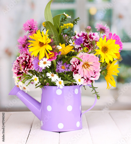 Photo: beautiful bouquet of bright flowers in watering can beautiful bouquet of bright flowers in watering can