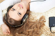 Foto: woman lying on carpet and listening to music woman lying on carpet and listening to music