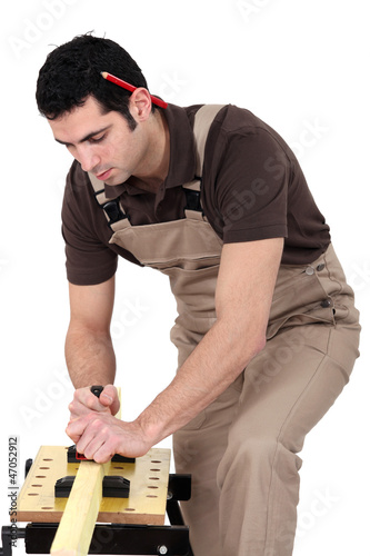 Photo: Man planning wood Man planning wood