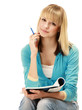 Photo: A pensive college girl with a pen and a textbook A pensive college girl with a pen and a textbook