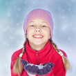 Foto: Smiling girl with snow in hands, blue background Smiling girl with snow in hands, blue background