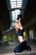 Woman lifting weights in urban setting