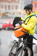 Photo: Young Male Cyclist Putting Package In Courier Bag Young Male Cyclist Putting Package In Courier Bag