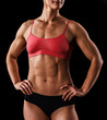 muscular female body against black background.