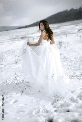 Photo: pretty young woman posing in wedding dress on winter snow pretty young woman posing in wedding dress on winter snow