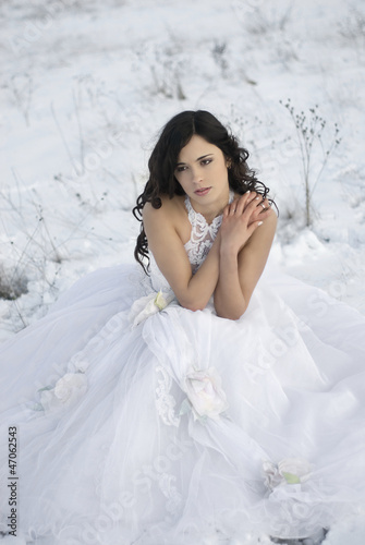 Photo: pretty young woman posing in wedding dress on winter snow pretty young woman posing in wedding dress on winter snow