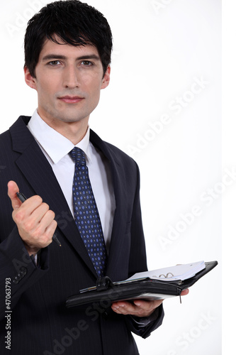 Photo: A businessman about to write on his agenda. A businessman about to write on his agenda.