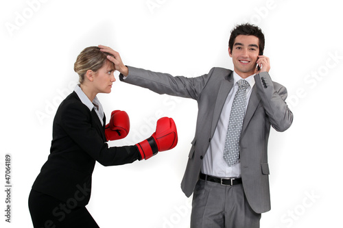 Photo: Businesswoman trying to box a man on a phone Businesswoman trying to box a man on a phone