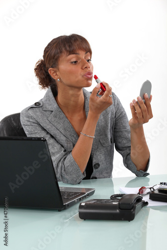 Photo: Businesswoman applying make-up Businesswoman applying make-up