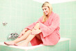 Hübsche Frau auf der Badewanne sitzend