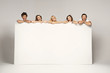 Photo: Happy joyful group of friends displaying white placard Happy joyful group of friends displaying white placard