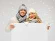 couple in a winter clothes holding blank board