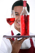 Waiter with a bottle and glass of rose wine