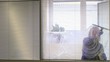 Professional maid cleaning and wiping window in office with soap