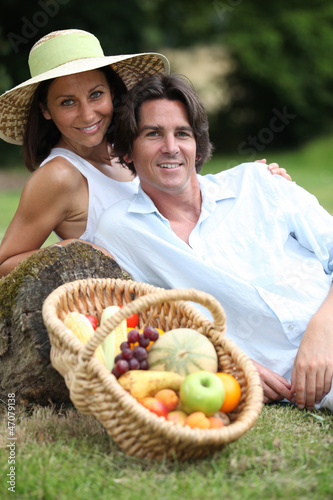 Photo: Couple posing with a fruit basket Couple posing with a fruit basket