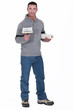 Man holding roll of wallpaper and brush
