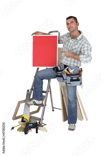 Photo: Carpenter proudly standing by equipment Carpenter proudly standing by equipment