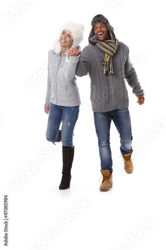Photo: Happy couple hand in hand at wintertime smiling Happy couple hand in hand at wintertime smiling
