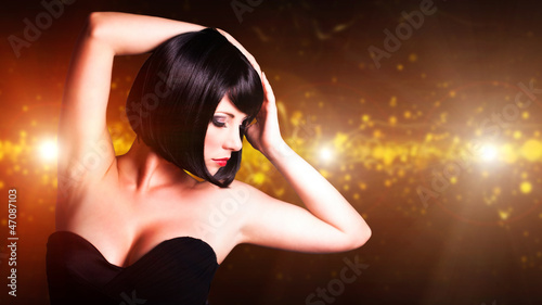 Photo: attraktive schwarzhaarige Frau vor Lichterhintergrund attraktive schwarzhaarige Frau vor Lichterhintergrund