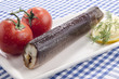 Räucheraal mit frischen Tomaten auf einem weißen Teller