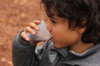 Outdoor autumn portrait of a boy with cup of tea