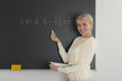 Lehrerin schreibt Matheaufgaben an die Tafel