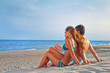 Photo: happy couple sitting on the beach happy couple sitting on the beach