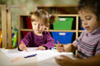 Children and fun, two preschoolers drawing in kindergarten