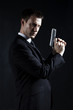 Secret agent holding handgun against black background