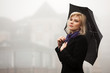 Young woman in autumn foggy morning