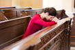 Young woman praying in a church