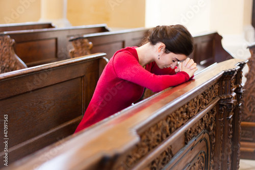 Photo: Young woman praying in a church Young woman praying in a church