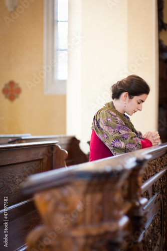 Photo: Young woman praying in a church Young woman praying in a church