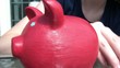 Girl Putting Coins in Piggy Bank