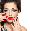Beautiful fashion model with red manicure and lips