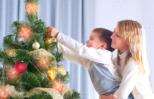 Photo: Kids Decorating Christmas Tree. Happy Children Kids Decorating Christmas Tree. Happy Children