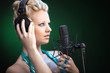 Hübsche Frau singt im Studio mit Micro und Kopfhörer