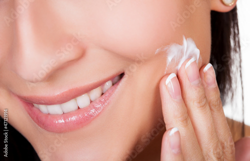 Photo: Young woman applying beauty product Young woman applying beauty product