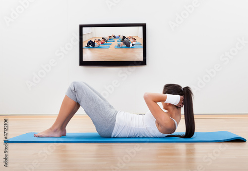 Photo: Athletic woman working out at home Athletic woman working out at home