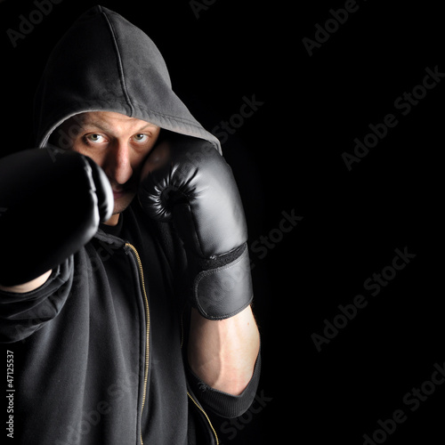 Photo: Young boxer over dark background Young boxer over dark background