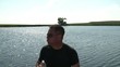 Man Drinks Water Bottle with Lake Background